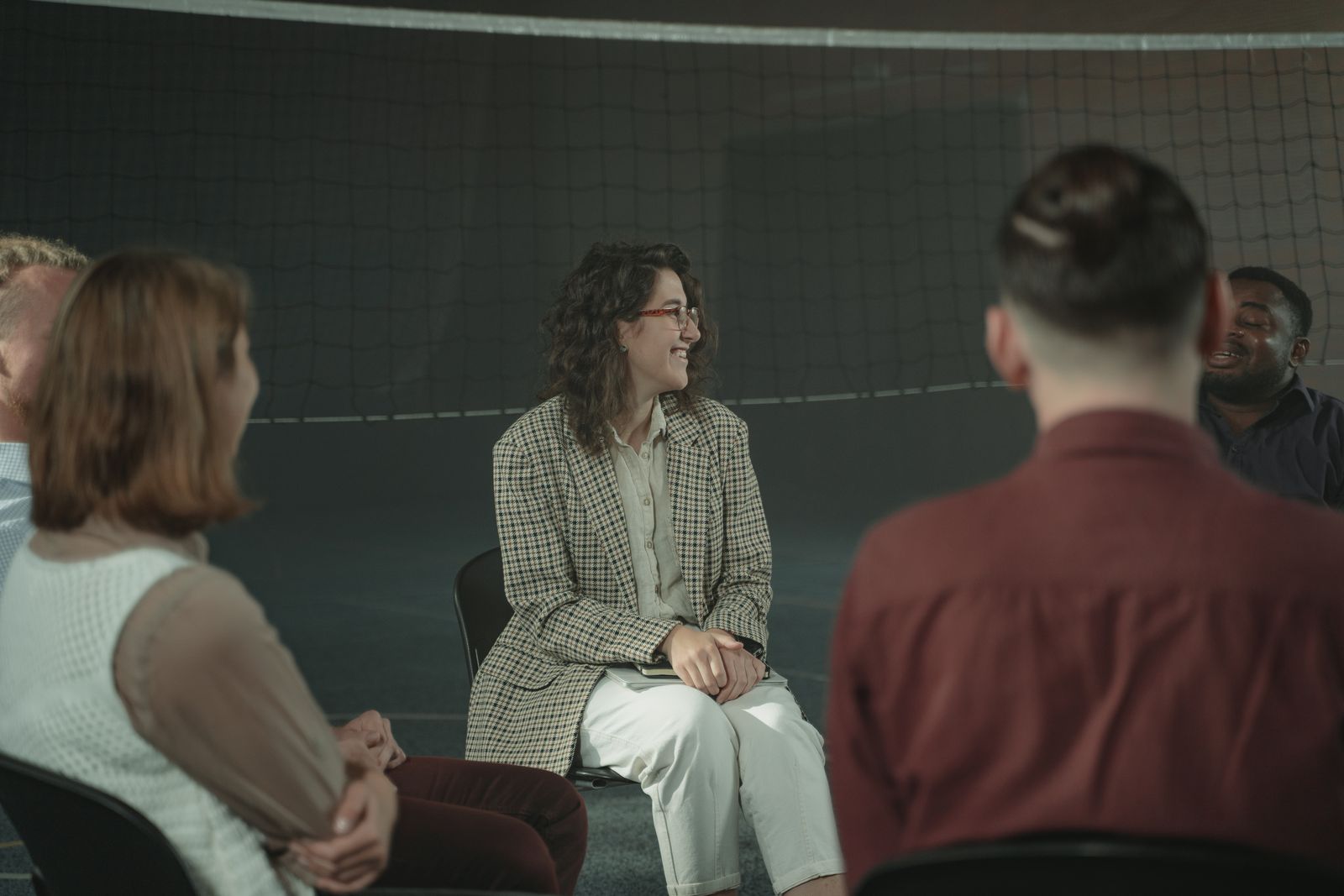 Adults sit in a circle sharing conversation and listening to one another.